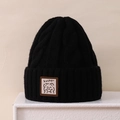Close-up of black cable-knit beanie featuring a Lucky cartoon bear patch detail - 3-8 Years / Black