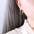 Deep blue enamel C-shaped hoop earrings with gold plating on female model - Blue Enamel Gold-Tone C-Shape Earrings