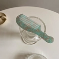 Detailed top view of a portable tortoiseshell acetate comb with blue marble texture - Jade Green