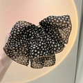 Detail eines Haargummis mit Leopardenmuster aus Mesh und goldenem Metallakzent - Schleife Federclip mit Leopardenmuster