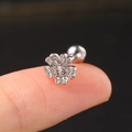 Macro shot of silver clover helix stud with clear zircons and ball screw back on finger - CC027-1 Silver Four Leaf Clover