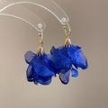 Dettaglio degli orecchini a fiore in chiffon blu con cappucci in metallo dorato - Blu