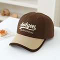 Dettaglio ravvicinato delle lettere ricamate su un cappellino da baseball in tela marrone e kaki - Bambino 3-6 Anni / Caffè Scuro