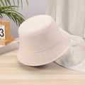 Detail of a beige cotton canvas bucket hat on a wooden surface with a soft sunlit background - One Size / Beige