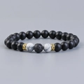Lava rock and marble bead aromatherapy bracelet with gold accents on a grey background - Howlite