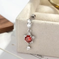Piercing de estrella plateada con circón rojo y piedras en una caja de tela - Rojo Granate