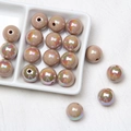 Macro shot of 16mm light brown acrylic beads with iridescent finish for DIY crafts - Tan