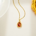 Gouden ketting met rode waterdruppel hanger en zirkonia op een witte achtergrond - Rode Zirkonia