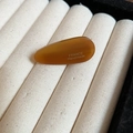Détail de la barrette goutte en acrylique ambre avec texte France Handmade sur velours beige - Clip Latéral Bec de Canard / Café Foncé