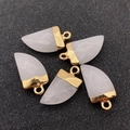 Macro view of five chili-shaped white natural stone pendants with gold metal caps - White Jade