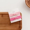Detail of pink bow hair clips with matte texture on display card in a wooden tray - Large Pink Bow One Pair