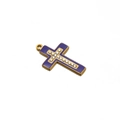 Dettaglio di un ciondolo a croce in smalto viola con metallo dorato e strass bianchi - Blu