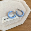Close-up of blue enamel C-shaped hoop earrings on a textured cotton linen background - Light Blue