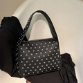 Black underarm bag with silver rivet studs on textured leather in a professional studio shot - Black
