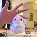 Pink and white plush hamster keychain with silver metal clasp held in hand - Plush Pink Hamster