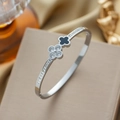 Zilveren klaver armband met zwart emaille en zirkoon op een beige juwelendoosje - Zilver