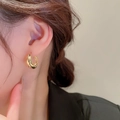 Close-up of golden twisted hoop earring on model showing minimalist metallic texture - 31# Gold Half-circle Twisted Earrings (Silver Earring Post)