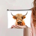 Detail of white highland cow print cosmetic bag held by hand with black zipper - Artistic Painting Highland Cow (jiayingpbb0116)