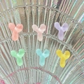Close-up of colorful Y-shaped resin hair clips in pastel tones on a shell background - Letter Y