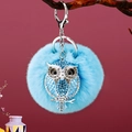 Blue rhinestone owl keychain with plush ball and silver lobster clasp on purple background - A430 Owl T Sky Blue Plush Ball