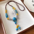 Collier ethnique en perles de céramique bleu ciel et jaune vif avec pompon - Gland en Céramique Bleu et Jaune