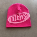 Primer plano del gorro de punto rosa con letras filthy sobre fondo de cemento gris - Rojo Rosa + Letras Rosadas