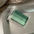 Macro shot of gradient green disposable micro brushes in clear zip lock packaging - Green