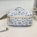 Dettaglio del beauty case trapuntato azzurro con gatti viola e motivi a tema marino - Medusa