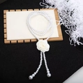 Dettaglio del fiore di camelia bianca con elegante cintura di perle su base in legno - Catena in vita con perle di camelia bianca / Bianco