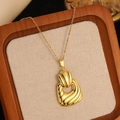 Detailed close-up of golden irregular pleated pendant necklace on beige linen tray - Gold Abstract Pleated Ripple Necklace