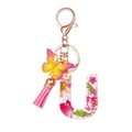 Detail of resin letter U keychain with dried flowers, gold foil, and pink tassel - Flower Pattern U