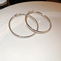 Vue détaillée de créoles argentées au design géométrique sur une assiette en céramique - 5cm / Argent