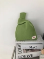 Close-up of grass green hollow-out knit handbag with honeycomb texture and woven label - Matcha Green