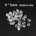 Nahaufnahme klarer Silikon-Ohrringverschlüsse in Größe 4x5 mm auf schwarzem Grund - Kugelform Mittel / 4*5mm 100 Stk./Packung
