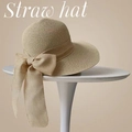 Elegante cappello di paglia kaki con grande fiocco su un tavolo da esposizione - Beige (D-317)