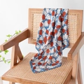 Blaues Seidentuch mit geometrischem Blumenmuster auf einem Rattanstuhl - Blau Rose