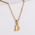 Macro detail of polished 18k gold letter D pendant on a minimalist stainless steel chain - Letter D