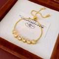 Detailed close-up of gold plated heart bracelet with zircon stones and adjustable slide clasp - Gold (White Zirconia)
