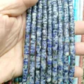 Close-up of blue and white natural stone spacer beads with cylindrical texture - Blue Spot Jasper