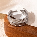 Minimalist silver feather open ring with detailed leaf texture on a wooden tray - Feather Style (18) / Steel