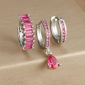 Macro view of silver earrings set featuring sparkling red gemstones and teardrop pendants - Three-Piece Set / Silver-Rose Red Zirconia