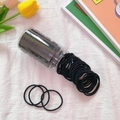 Jar of small black elastic hair bands for girls, displayed on a textured white fabric - 100Pcs Black Canned