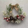 Close-up of frosted Christmas wreath with pine needles, red berries and a burlap bow - Burlap Bow and Snowy Pine Cone