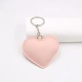 Detalle del llavero de corazón en cuero PU rosa con costuras y anillo plateado - Rosa