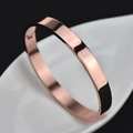 Polished rose gold stainless steel clasp bangle bracelet on white ceramic tray - Circumference 18cm / 8mm Rose Gold