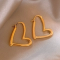 Close-up of polished gold heart hoop earrings on champagne silk fabric background - Gold Heart