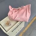 Pink canvas tote bag with large capacity and brand label shown in a lifestyle setting - Pink