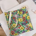 Vista piatta della borsa in cotone con stampa di fragole e fiori e manico in tessuto - Foglie Verdi Fiori Gialli