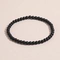 Nahaufnahme eines mattschwarzen Naturstein-Perlenarmbands mit feiner Textur - Mattes Onyx