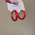 Detail view of red enamel C-shaped hoop earrings on display card with golden metal clasp - Medium Smooth Round (Silver Needle) / Glossy Bright Red